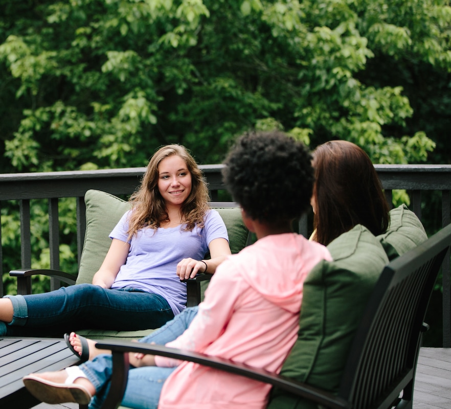 Teens relaxing during free time on the back porch