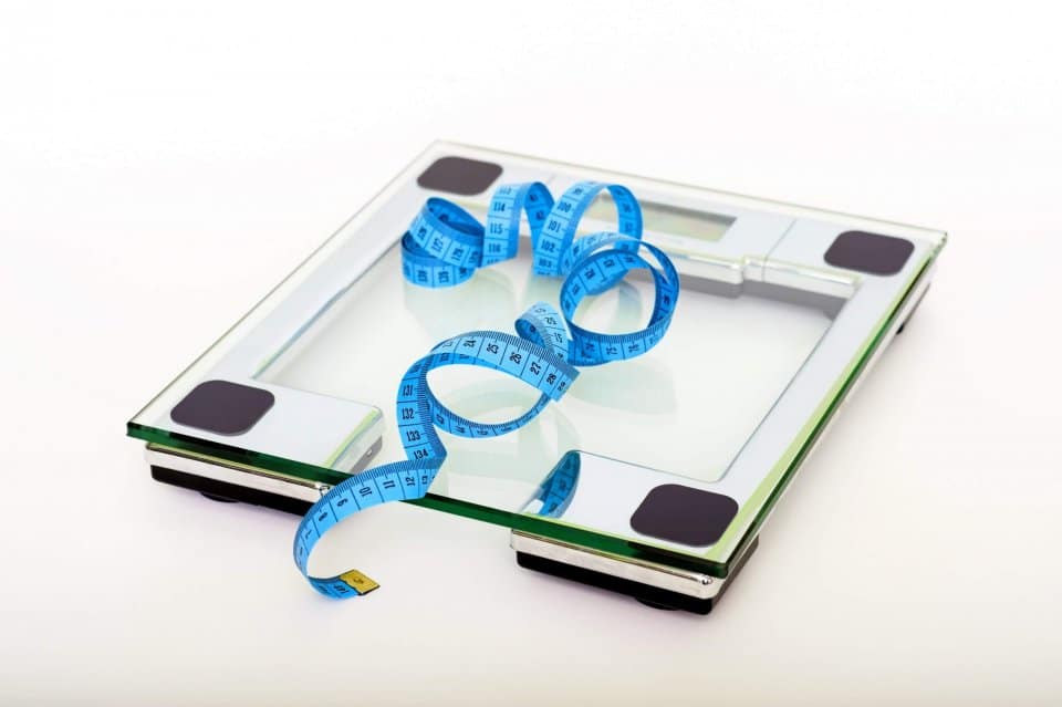 blue-tape-measuring-on-clear-glass-square-weighing-scale-53404