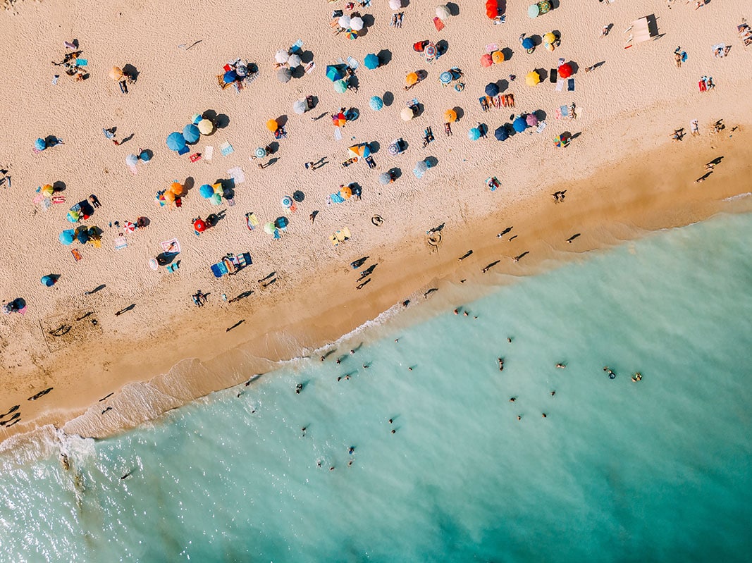 Aerial View From Flying Drone Of People Crowd Relaxing On Algarve Beach In Portugal