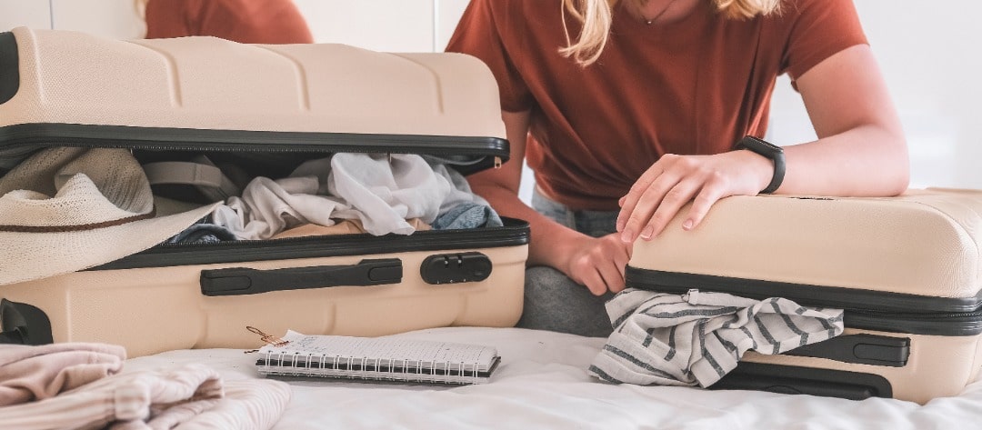 A woman packing a couple of suitcases.